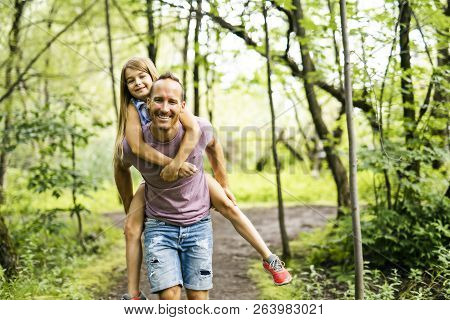 Father Giving His Daughter A Piggyback Ride, Having Fun