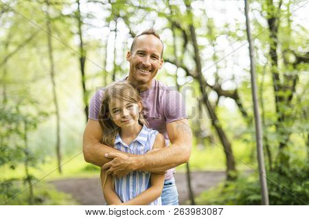 Father Having Fun In Forest With His Daughter