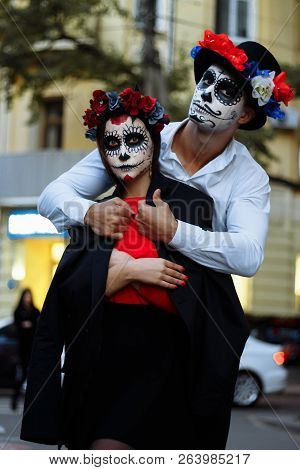 A Couple, Wearing Skull Make-up For. All Souls Day. Boy And Girl Sugar Skull Makeup.painted For Hall