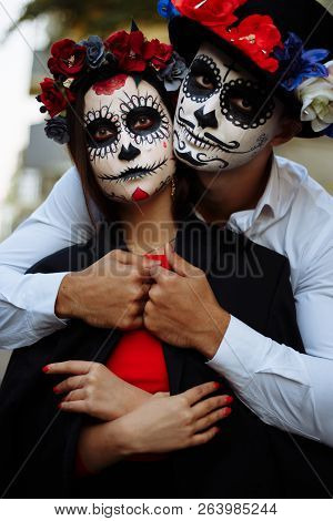 A Couple, Wearing Skull Make-up For. All Souls Day. Boy And Girl Sugar Skull Makeup.painted For Hall