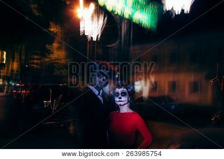 Blur. A Man And A Woman With A Visage, A Pattern Of Skulls, A Zombie On The Face. Dead At Night. A P