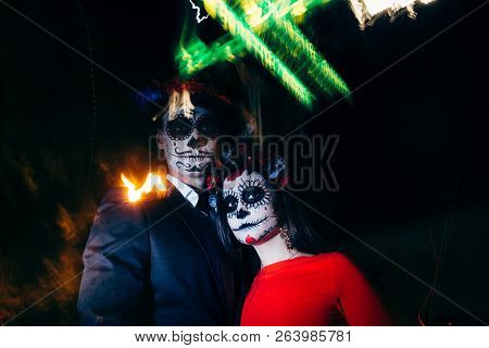 Blur. A Man And A Woman With A Visage, A Pattern Of Skulls, A Zombie On The Face. Dead At Night. A P