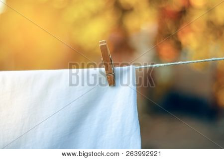 White T-shirt Hanging On A Clothespin Nature On Blur Background