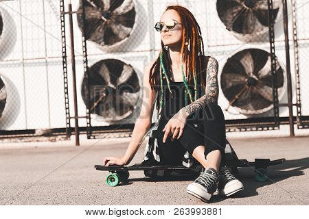 Young Girl With Tattoo And Dreadlocks On Urban Industrial Background