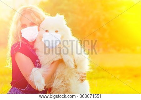 Beautiful Curly Blonde Smiling Happy Young Woman In Denim Shorts And Mask Playing Embraces A White F