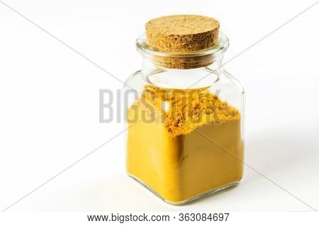 Turmeric Powder In Glass Transparent Bottle On The White Background Isolated. Health Care, Alternati