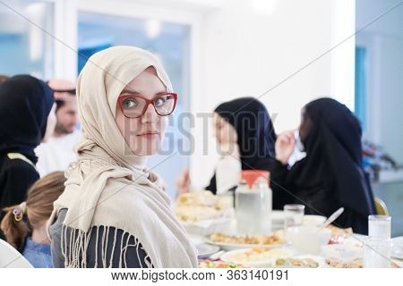 young muslim woman having Iftar dinner with family Eating traditional food during Ramadan feasting month at home. The Islamic Halal Eating and Drinking Islamic family