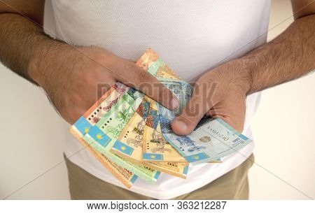 Kazakhstan National Currency. Kz Money Banknotes. Man In White T Shirt  Holds Tenge Banknotes In His