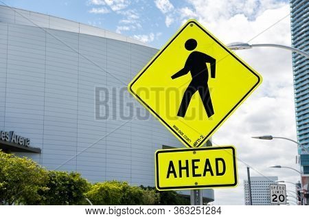 Miami, Usa - February 29, 2016: Traffic Sign Urban Background. Yellow Triangle Sign With Pedestrian 