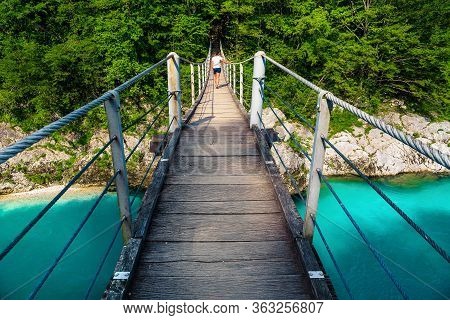 Stunning Hiking Trail With Hiker On The Suspended Bridge Over The Isonzo River In The Forest, Kobari