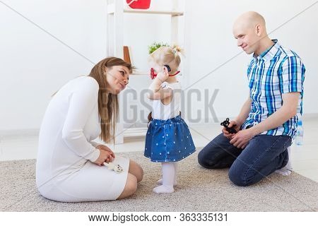 Hearing Aid In Baby Girls Ear. Toddler Child Wearing A Hearing Aid At Home. Disabled Child, Disabili