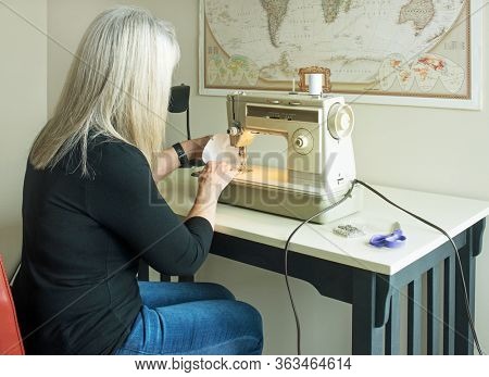 DAYTON, OHIO - APRIL 24, 2020: Woman sews homemade face masks from Hepa sweeper bags for use during COVID-19 pandemic as N95 masks are being reserved for medical personnel. Hepa filters filter 99.97%.