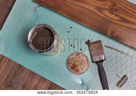 Painting lumber with wood stain coloring with paint brush