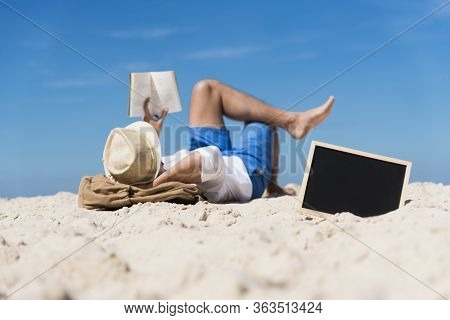 Man On Summer Island Beach Relax During Holiday Vacation. Lifestyle Happy Tan Skin Man Reading Book 