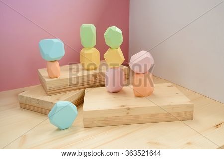 Abstract Figures From Elements Of Wooden Tumi Ishi Pastel Colors On A Wooden Podium On A Paper Backg