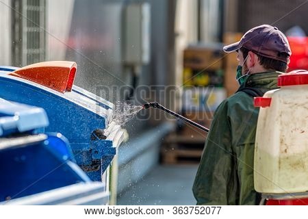 Man In Protective Suit Disinfects And Spraing Public Places.