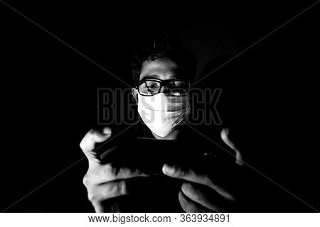 Portrait Of A Young Man Playing Mobile Video Games At Night Deu To Coronavirus Epidemic.