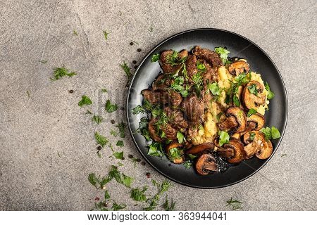 Stewed Beef With Mushrooms And A Side Dish Of Lentils On A Black Plate. Top View With Place For Text
