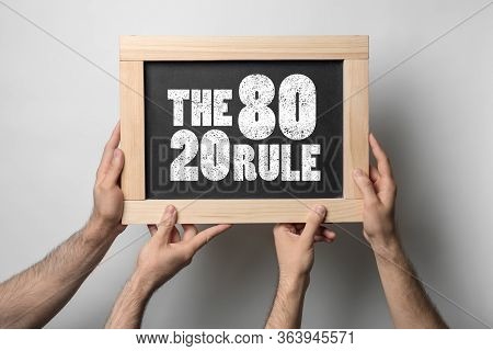 Pareto Principle Concept. People Holding Blackboard With 80/20 Rule Representation On Light Backgrou