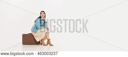 Stylish Young Woman Sitting On Vintage Suitcase With Deay Look Isolated Over White Background. Trave