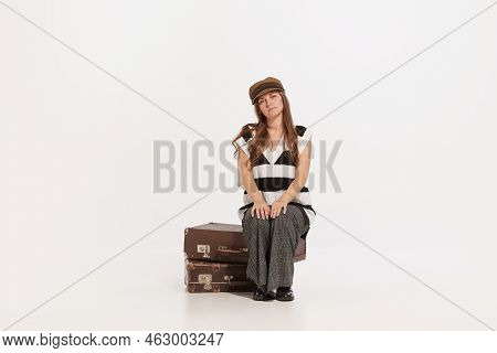 Stylish Young Woman Sitting On Vintage Suitcase With Deay Look Isolated Over White Background. Trave