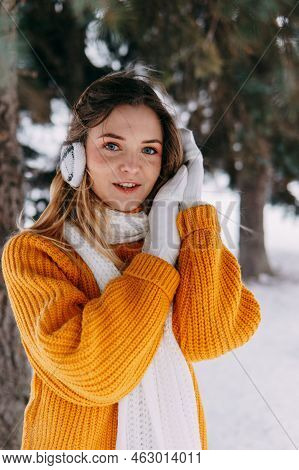 Teen Blonde In A Yellow Sweater Outside In Winter. A Teenage Girl On A Walk In Winter Clothes In A S