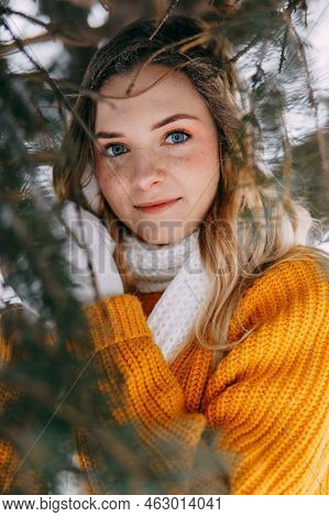 Teen Blonde In A Yellow Sweater Outside In Winter. A Teenage Girl On A Walk In Winter Clothes In A S