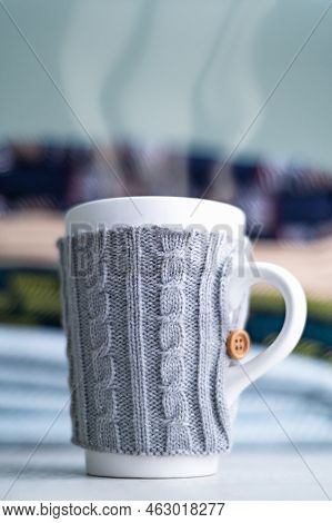 Stack Of Folded Woolen Checked Blankets And Mug In Wollen Cover, Autumn And Cold Winter Concept