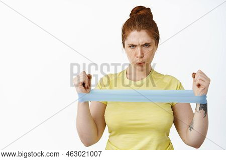 Serious Redhead Curvy Woman Doing Workout With Resitance Band, Fitness Exercises On Arms, Stretching