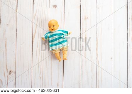 Old Plastic Mini Baby Doll Toy Wearing A Striped Sweater. Toy Is Antique From The 1980s