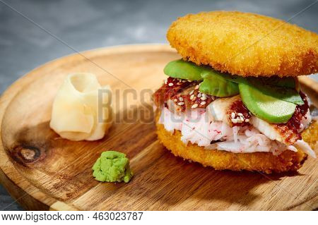 Pan-asian Cuisine Concept. Japanese Sushi Burger Made From Rice Bread, Crab Meat, Avokado And Wasabi