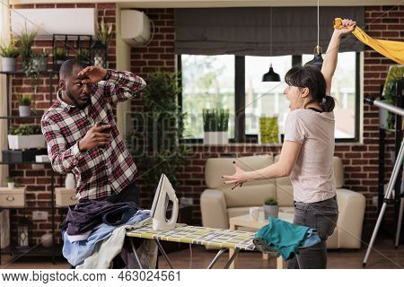 Nervous Upset Woman Trying To Hit Husband While Having A Big Fight At Home. Multiracial Couple Argui