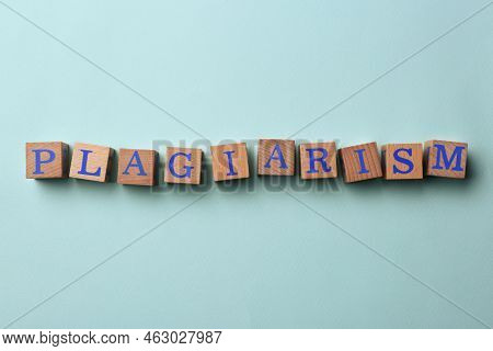 Wooden Cubes With Word Plagiarism On Turquoise Background, Flat Lay