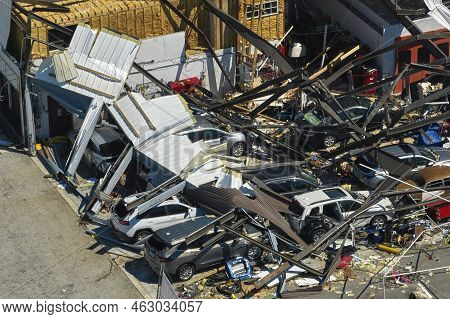 Hurricane Ian Destroyed Industrial Building With Damaged Cars Under Ruins In Florida. Natural Disast