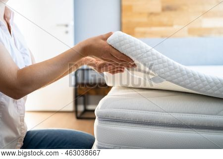 Mattress Topper Being Laid On Top Of The Bed