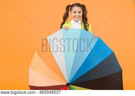 Symbol Of Protection. Hiding From Rain. Smiling Schoolgirl Peeking Out Of Colorful Umbrella. Autumn 