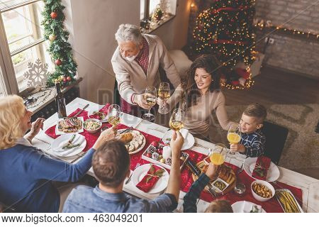 High Angle View Of A Beautiful Happy Family Gathered Around The Table, Having Christmas Dinner All T
