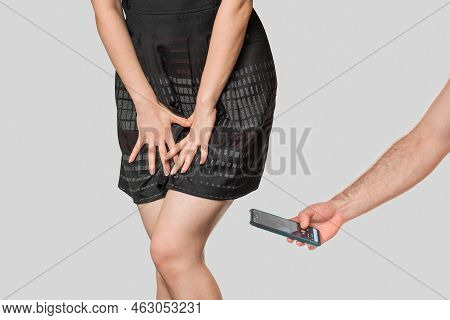 A Man Secretly Takes Pictures Of The Buttocks And Underwear Under The Skirt Of A Woman Hiding Behind