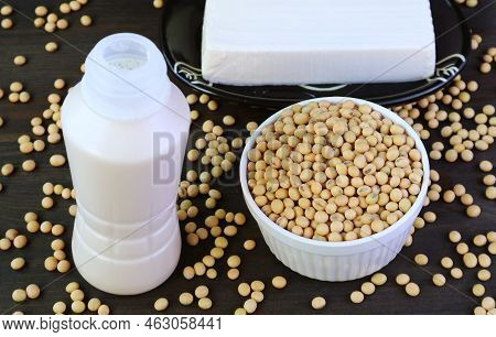 A Bottle Of Soy Milk With Dried Soybeans And Tofu On Black Wooden Table