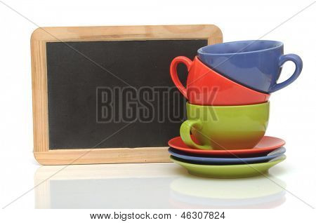 Set van kleurrijke kopjes met schoolbord op wit. Tea time
