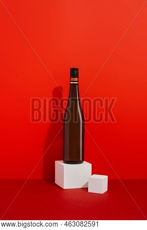 Bottle Of Wine On Red Background With Deep Shadows. Mock Up Drink With Place For You Lable And Text