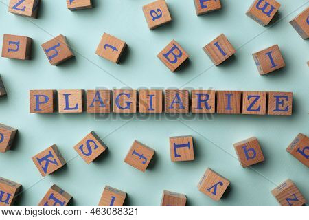 Wooden Cubes With Word Plagiarize On Turquoise Background, Flat Lay