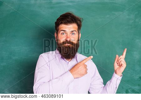 Blank Chalkboard With Copy Space. Portrait Of A Funny Teacher Or Professor Near Blackboard. Thinking