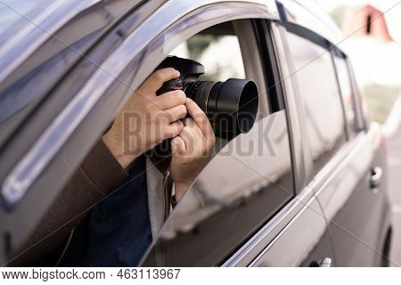 Private Detective Or Investigator Or Paparazzi Taking Photos On Street While Sitting In Car