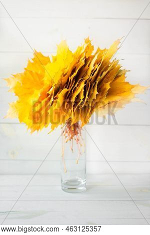 A Bouquet Of Autumn Maple Leaves In A Vase Against A White Tree Background. Autumn Composition.