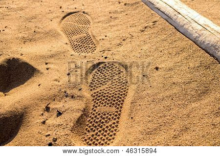 Rastros del paso de zapatos de mar playa de arena-lado