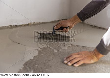 Construction Workers Are Painting The Floor Using The Method Self-leveling Epoxy.spreading Self Leve