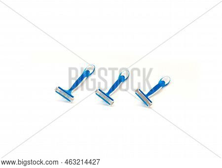 Three Brand New Blue And White Plastic Disposable Razors With Ergonomic Handle Isolated On White Bac