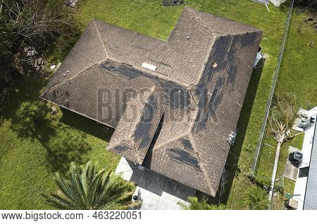 Wind Damaged House Roof With Missing Asphalt Shingles After Hurricane Ian In Florida. Repair Of Home