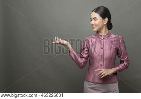 A Young Asian Woman Wearing Thai Traditional Cloth On Gray Background